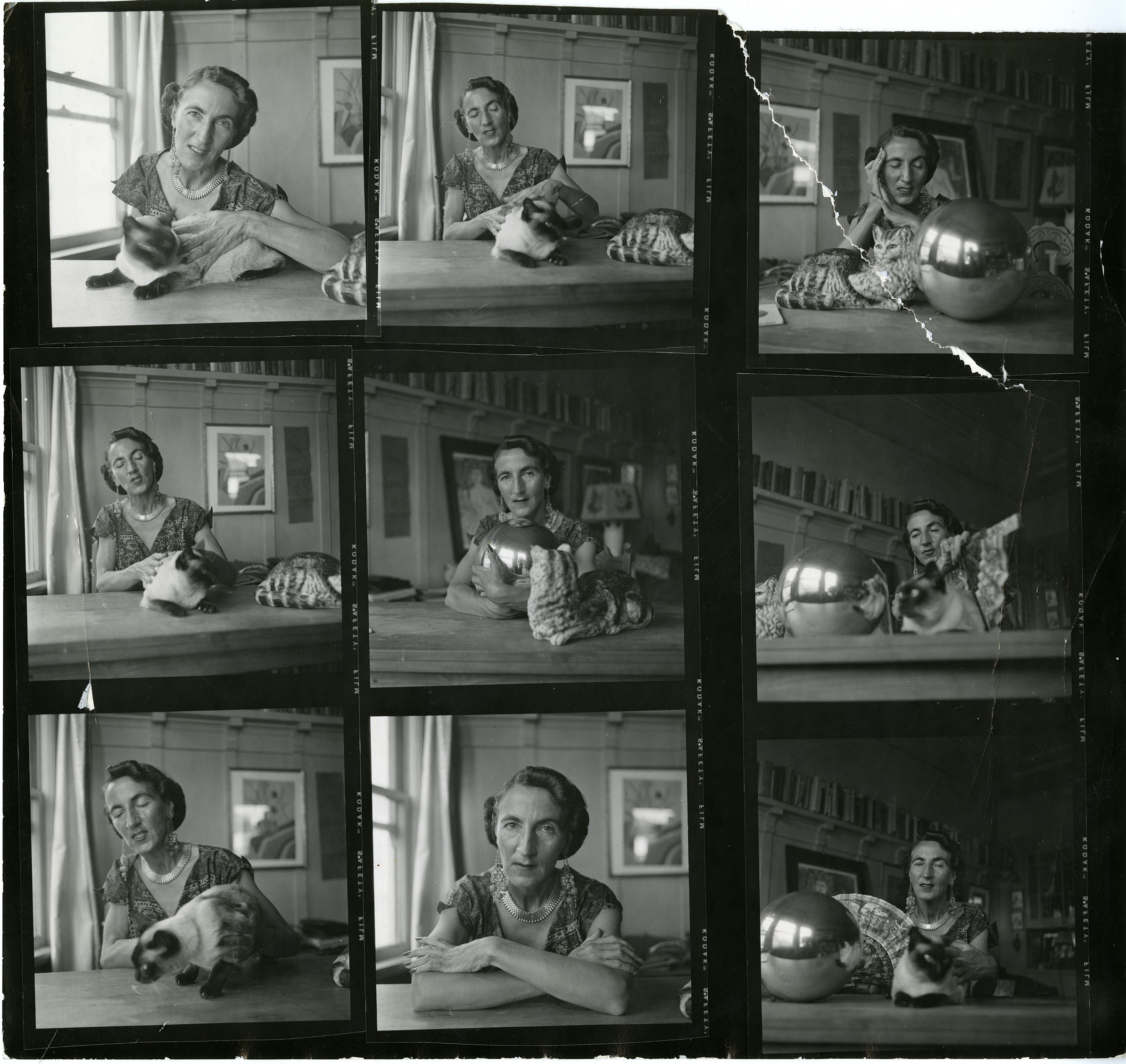 A contact sheet of nine photographs of Helen Adam, sometimes alone, sometimes with her cat, sometimes with cat and large metal sphere. There's a tear in the photograph at upper right.