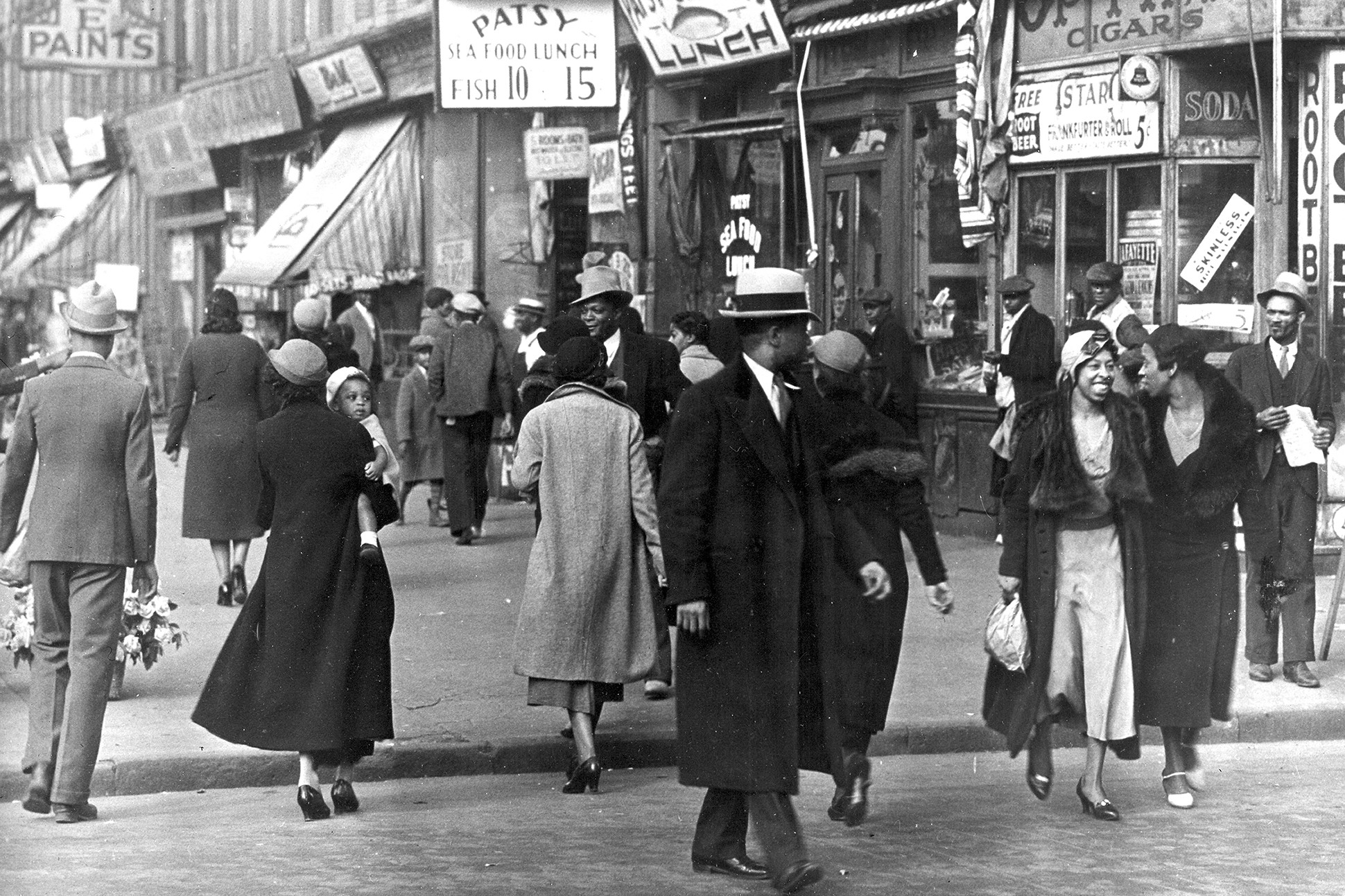 Black and white image of a street scene in Harlem in the 1930s.