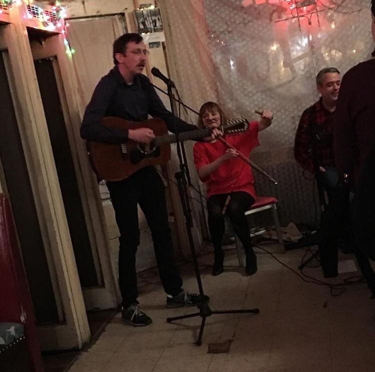 Edmund Berrigan playing guitar and singing with band.