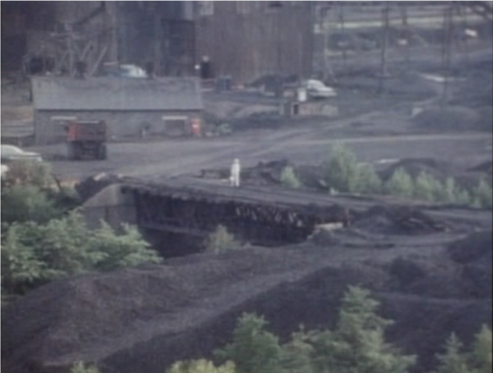 Film still from Barbara Loden’s WANDA, figure walking across a coal mine.