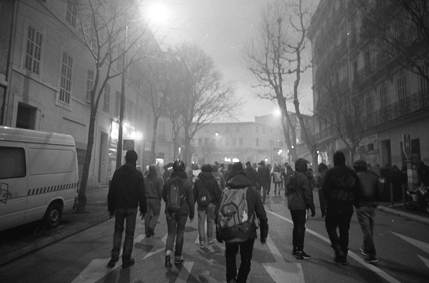 Paris protesters walking, backs turned.