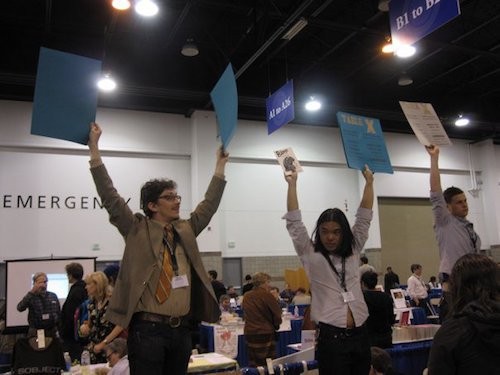 Ugly Duckling Presse staff holding posters for Table X at AWP conference