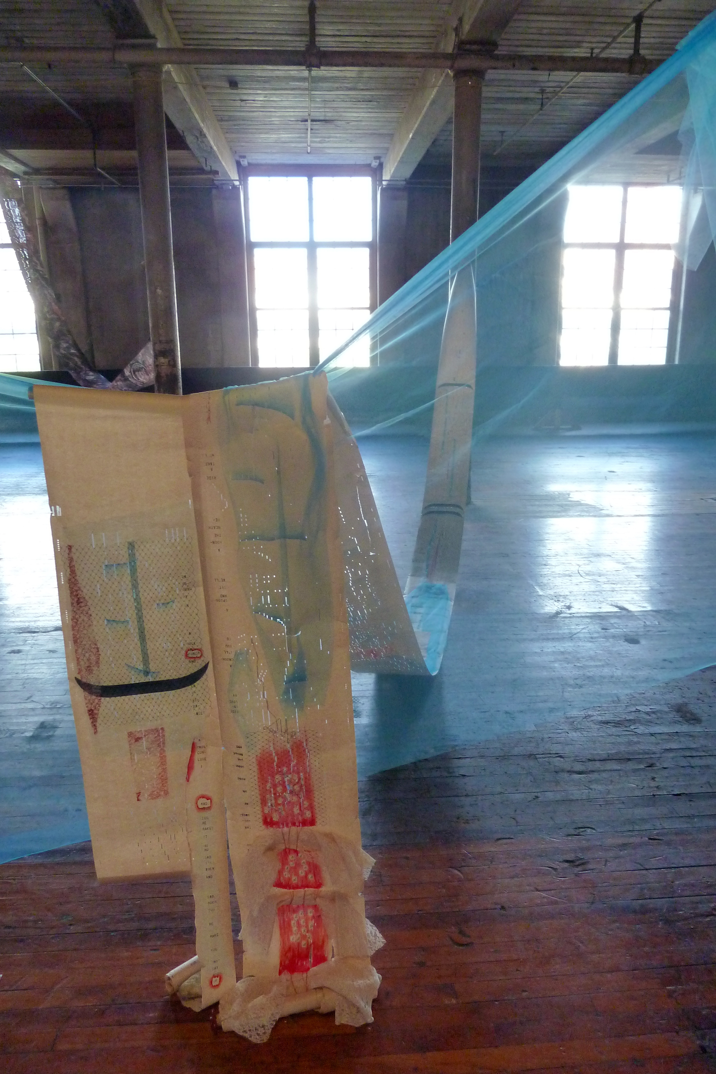 Hand-printed piano paper draped over transparent blue mesh cloth.