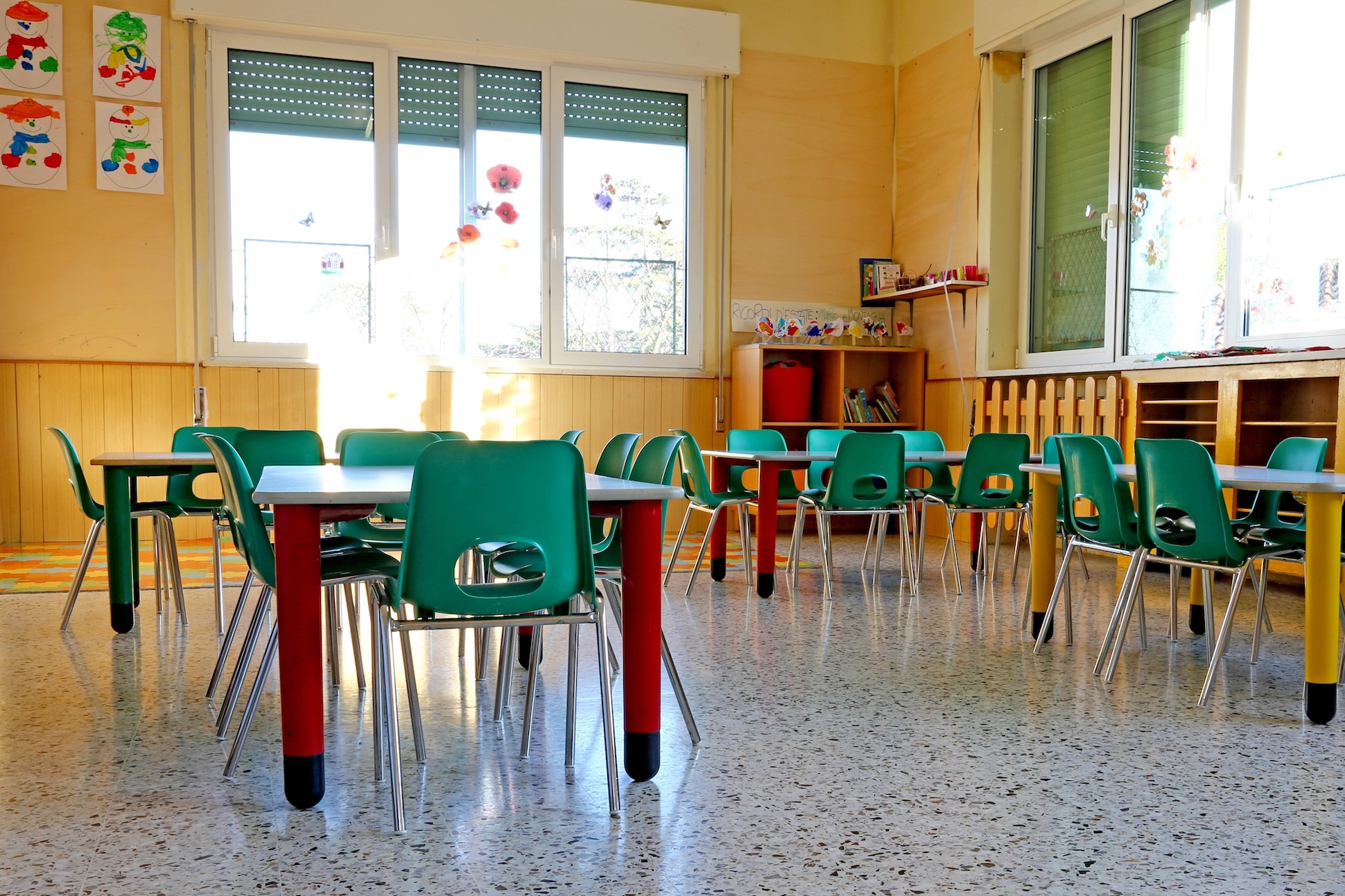 Small student seating with green chairs and tables.