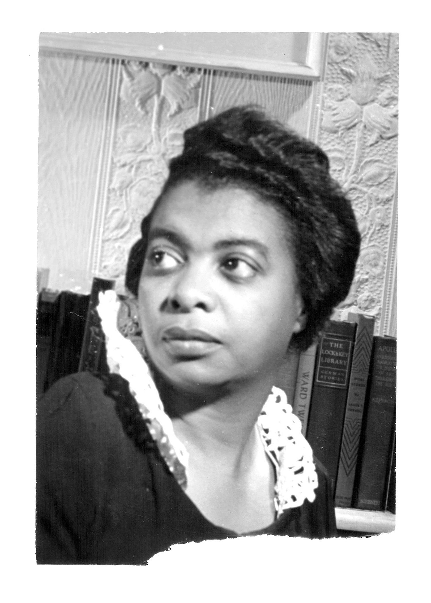 A black and white portrait of a black woman with laced collar in front of a bookshelf 